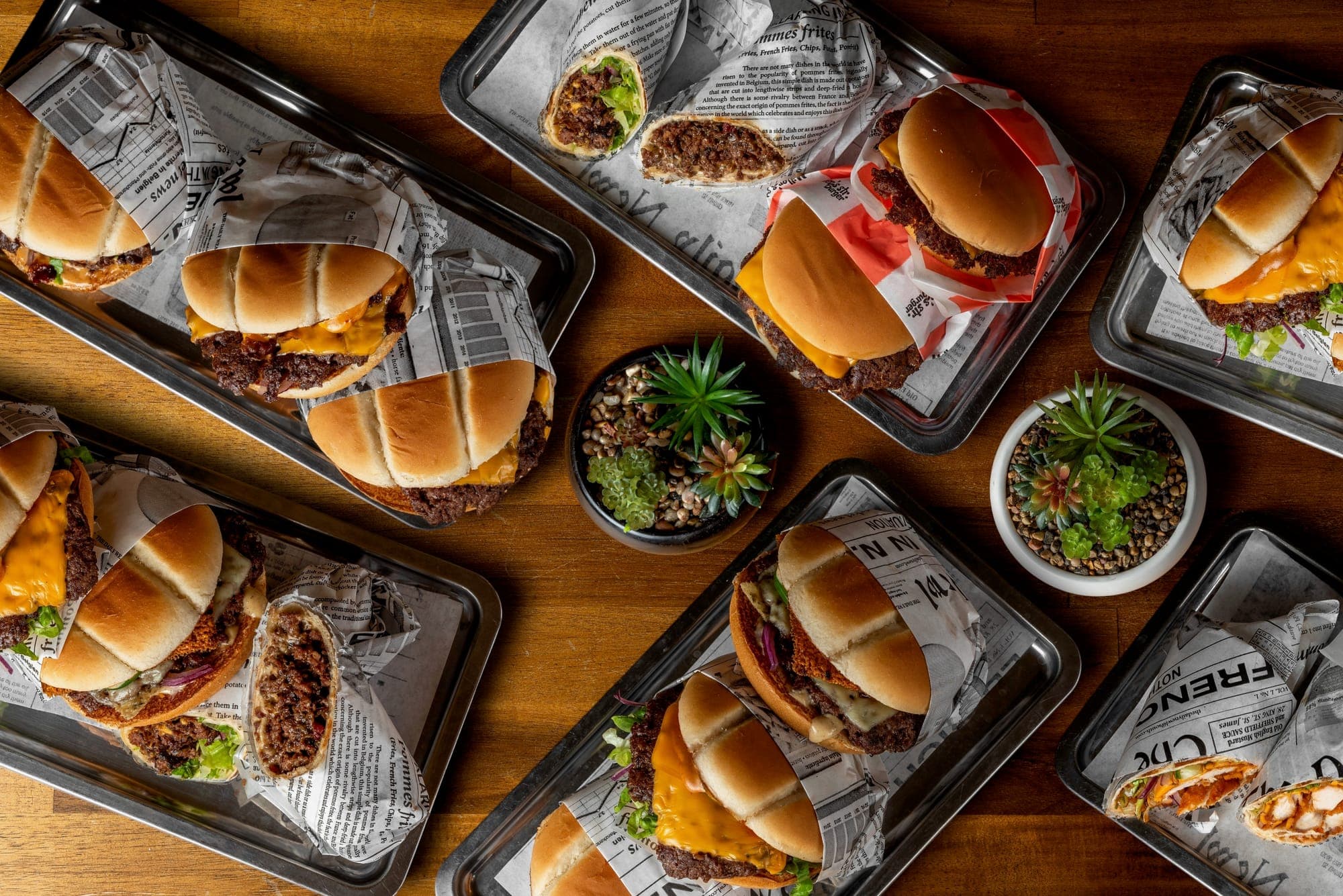 Miller's smash burgerek, rollok és wrapek tálcákon, felülnézetből